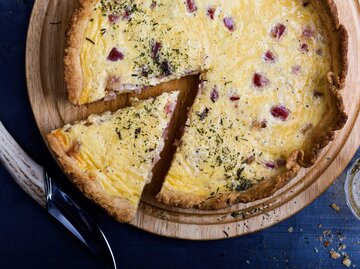 Eine große Quiche Lorraine mit einem herausgeschnittenem Stück | © Getty Images/istetiana