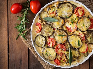 Eine Auflaufform mit veganem Kartoffelgratin und frischen Kräutern | © Getty Images/Elena_Danileiko