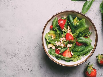Eine Salatschüssel mit Erdbeeren,  Avocado und Minze | © Getty Images/Anna Puzatykh