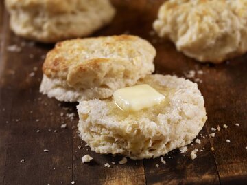 Ein aufgeschnittenes Buttermilchbrötchen mit einem Stück Butter | © Getty Images/LauriPatterson