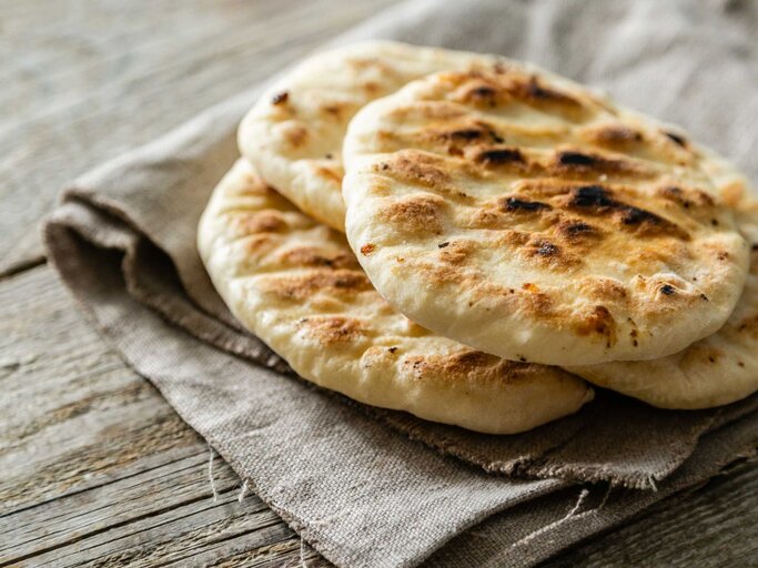 Traditionelles Pita-Brot auf rustikalem Holzhintergrund | © Getty Images/a_namenko