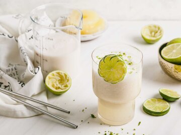 Sommer-Smoothie. Hergestellt mit Kokosmilch, frischem Limettensaft, Limettenschale und Ananas. Serviert in einem Glas und garniert mit einer Scheibe Limette | © Getty Images/Alesya Makina