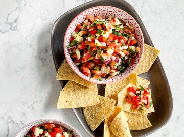 Schalen mit Salsa und Mais-Chips auf weißem, marmoriertem Hintergrund | © Getty Images/Claudia Totir