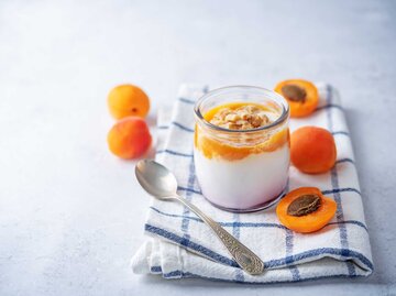 Aprikosen-creme in einem Dessertglas mit etwas Aprikosenpüree | © Getty Images/nata_vkusidey