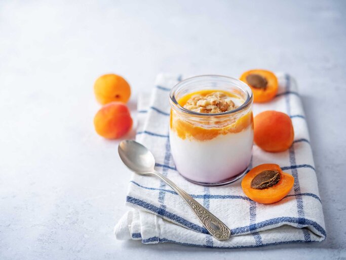 Aprikosen-creme in einem Dessertglas mit etwas Aprikosenpüree | © Getty Images/nata_vkusidey