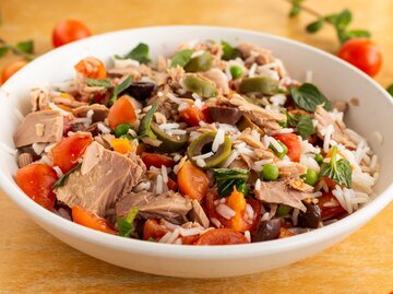 Eine Schüssel Reissalat mit Thunfisch auf einem Holztisch, Nahaufnahme | © Getty Images/Noemi Toscano