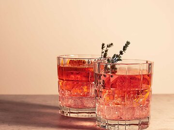 Zwei Gläser Sunset Spritz mit Lavendel garniert, Aufnahme von der Seite | © Getty Images/Jane Vershinin