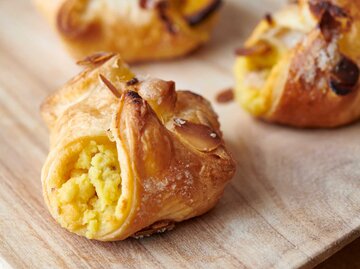 Drei kleine Apfelstrudel auf einer Tischplatte | © Getty Images/Giovanni Bortolani