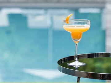 Ein Cocktailglas mit orangenem Inhalt vor einem blauen Hintergrund | © Getty Images/Westend61