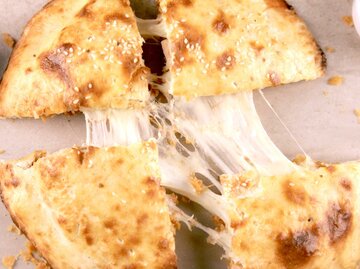 In vier Teile getrenntes Mozzarella Brot mit Käsefäden in der Mitte | © Getty Images/Saminaleo