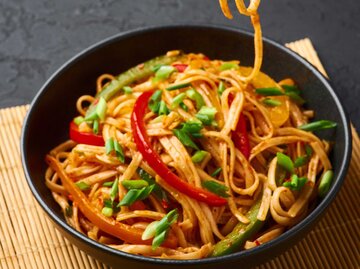 Vegetarische Schezwan Nudeln oder Gemüse Hakka Nudeln oder Chow Mein in schwarzer Schüssel auf dunklem Hintergrund. | © Getty Images/Andrei Kravtsov