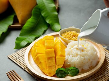 frische reife Mango und Klebreis mit Kokosnussmilch auf dunklem Hintergrund | © Adobe Stock/artit