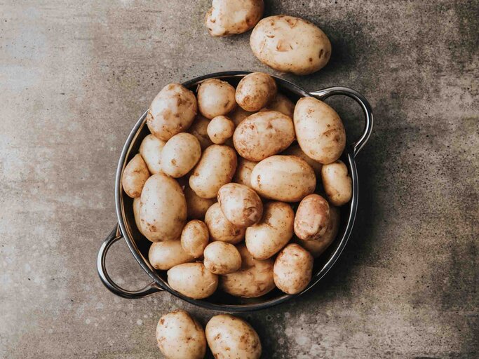 Ungeschälte Kartoffeln in einem Topf | © Getty Images/Yulia Naumenko