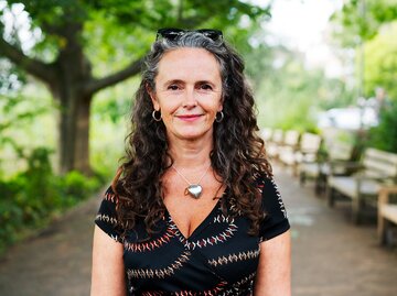 Eine Frau ist in der Natur und lächelt | © GettyImages/Tim Robberts