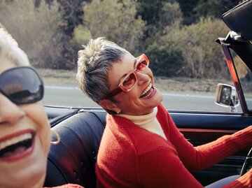 Frau mit Sonnenbrille sitzt im Cabrio | © Getty Images/The Good Brigade