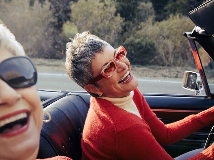 Frau mit Sonnenbrille sitzt im Cabrio | © Getty Images/The Good Brigade