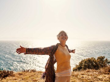 Frau streckt glücklich die Arme aus | © Getty Images/pixdeluxe