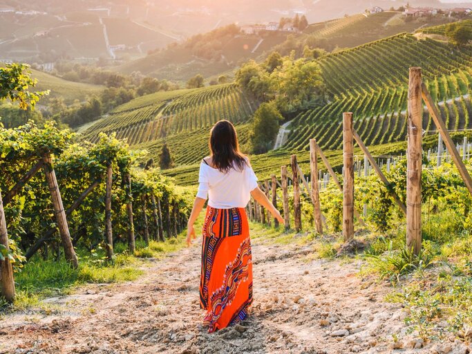 Person geht durch Weinplantage | © Getty Images/Marco Bottigelli