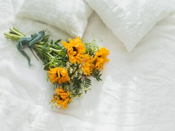 Sonnenblumenstrauß auf Bett | © Getty Images/Anastasiia Krivenok