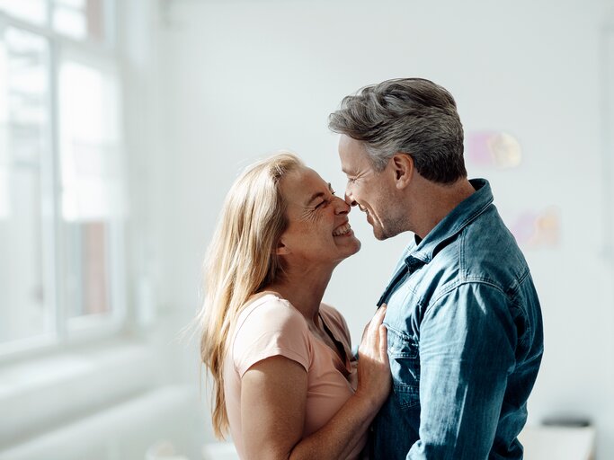 Eine Frau und ein Mann umarmen sich und grinsen sich an | © GettyImages/Westend61
