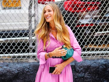 Sarah Jessica Parker in pinkem Kleid mit Handtasche unter dem Arm | © Getty Images/Gotham