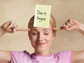 Frau mit "Don't forget"-Post-it auf der Stirn | © Getty Images/Peter Dazeley