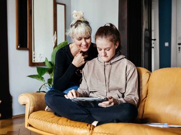 Mutter und Tochter schauen gemeinsam auf ein iPad | © Getty Images/Tom Werner