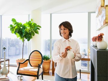 Frau steht im aufgeräumten Wohnzimmer | © Getty Images/Gravity Images