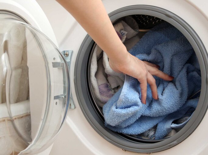 Person legt Wäsche in die Waschmaschine | © Adobe Stock/Alexandr Denisenko