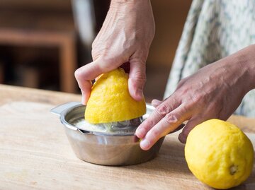 Nahaufnahme einer Hand, die eine Zitrone auspresst | © Getty Images / Westend61