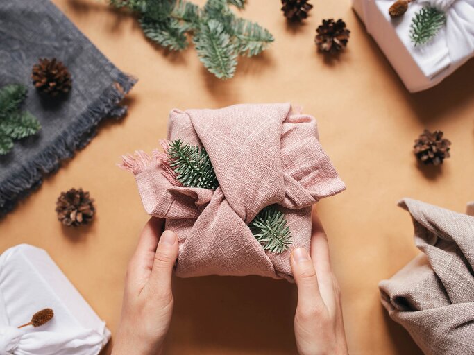 In Stofftücher eingewickelte Weihnachtsgeschenke | © AdobeStock/Alex Shi