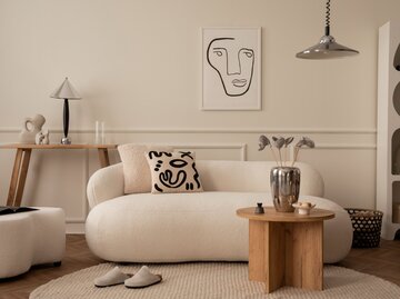 Wohnzimmer mit Stoffsofa, Holztisch und Accessoires aus Chrom | © AdobeStock/FollowTheFlow