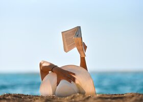 Eine Frau liest am Strand ein Buch