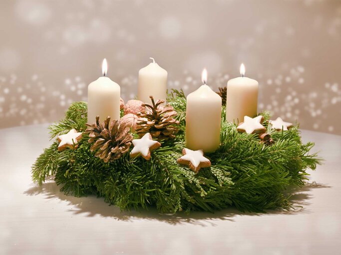 Adventskranz mit Zimsternen geschmückt und drei brennenden Kerzen. | © Adobe Stock/Maren Winter