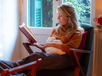 Person liest mit Wärmflasche in Sessel | © Getty Images/Kathrin Ziegler