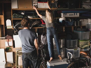 Eine Frau räumt eine volle Garage auf | © Getty Images / Maskot