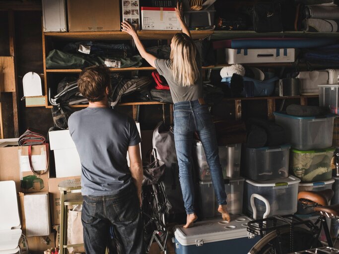 Eine Frau räumt eine volle Garage auf | © Getty Images / Maskot