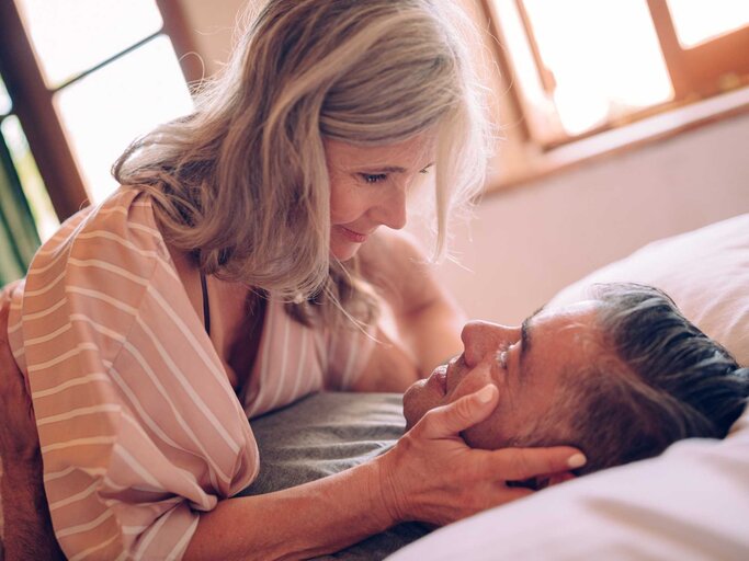 Paar liegt im Bett zusammen | © Getty Images/wundervisuals