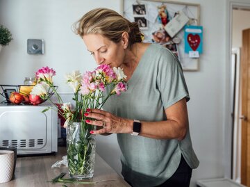 Eine Frau riecht an einem Blumenstrauß  | © Getty Images / SolStock