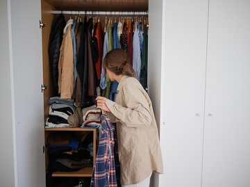 Frau organisiert Kleiderschrank | © AdobeStock/Lais