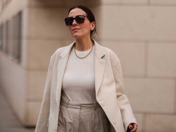 Dunkelhaarige Frau mit beigem Tanktop, beigem Blazer und beiger Hose | © Getty Images/Jeremy Moeller