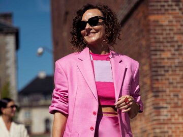 Renia Jaz trägt einem pinken Zweiteiler mit Rock auf der Fashion Week in Kopenhagen. | © Getty Images / Raimonda Kulikauskiene