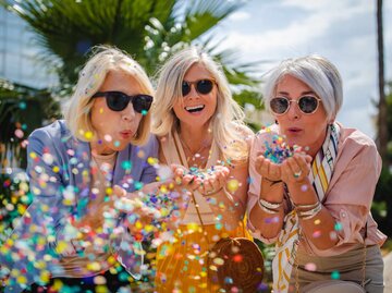 Drei reife Frauen haben Spaß und werfen Konfetti | © Getty Images/wundervisuals