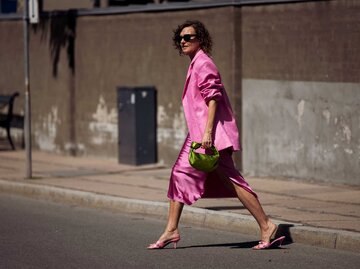 Streetstyle von Renia Jaz in einem pinken Look bestehend aus einem Blazer, Rock und Mules | © Getty Images/Raimonda Kulikauskiene 
