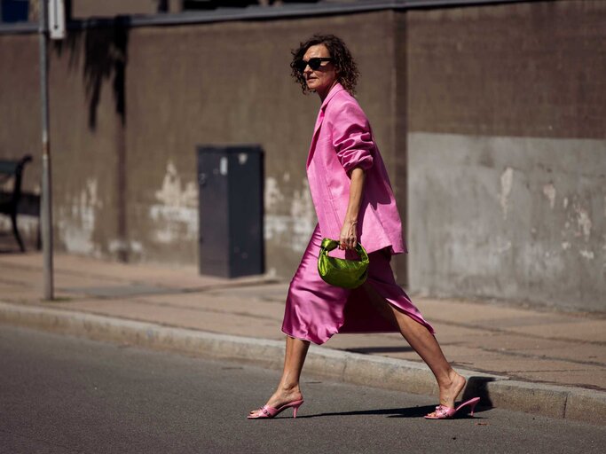 Streetstyle von Renia Jaz in einem pinken Look bestehend aus einem Blazer, Rock und Mules | © Getty Images/Raimonda Kulikauskiene 