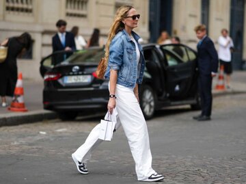 Frau trägt weiße Hose und Jeansjacke | © Getty Images/Edward Berthelot 