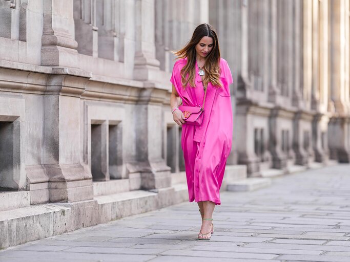 Streetstyle von Frau in pinkem Kleid mit pinker Tasche | © Getty Images/Edward Berthelot