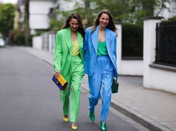 Alexandra Lapp trägt einen grellgrünen, Blazer, Hose, gelbes Oberteil. Isabel Lapp trägt blauen Anzug, grünes Seidenoberteil  | © Getty Images/Jeremy Moeller