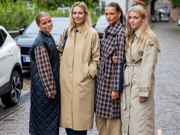 Vier Frauen stehen auf der Straße zusammen und tragen unterschiedliche Mäntel. | © Getty Images / Christian Vierig
