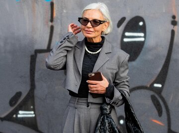 Streetstyle: Grece Ghanem in einem kurzen, grauen Blazer mit farblich passender Hose | © Getty Images/Christian Vierig 